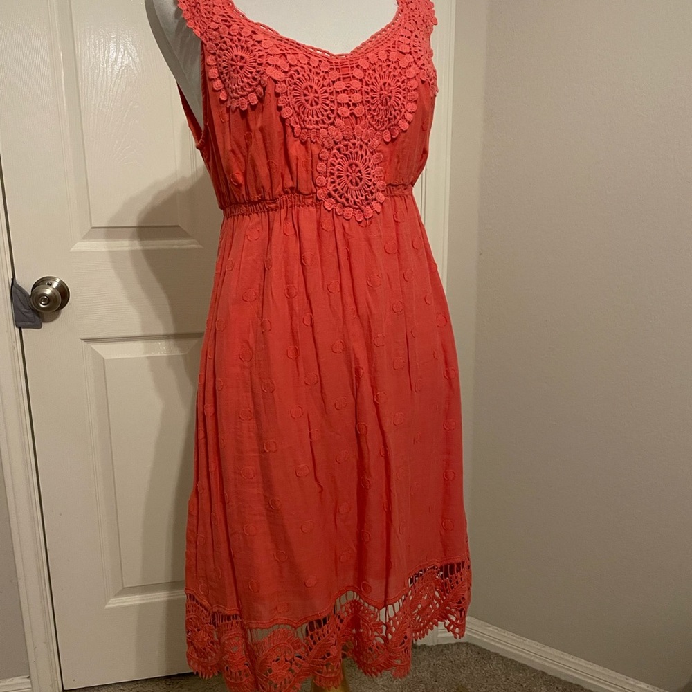 Coral summer dress with crochet details and embroidered dots.